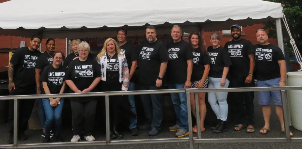 FGI employees in United Way Live United shirts volunteering under a tent